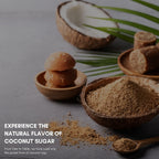 Coconut sugar in a wooden bowl with a coconut and cookies on a gray background.