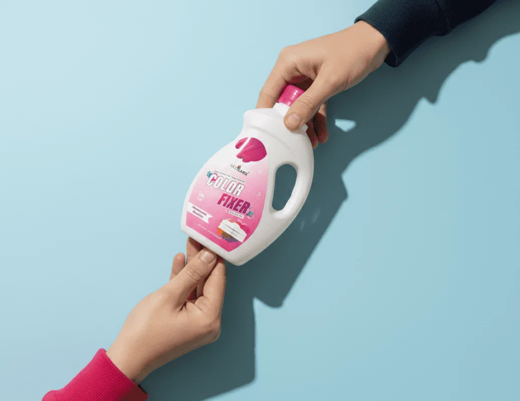 Person handing over a bottle of 'Stain Fixer' with pink label against a light blue background
