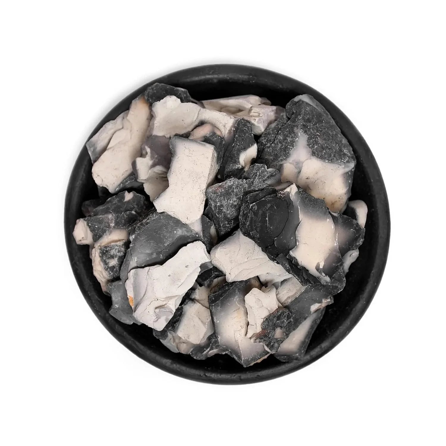 Black and white stone chips in a black bowl on a white background